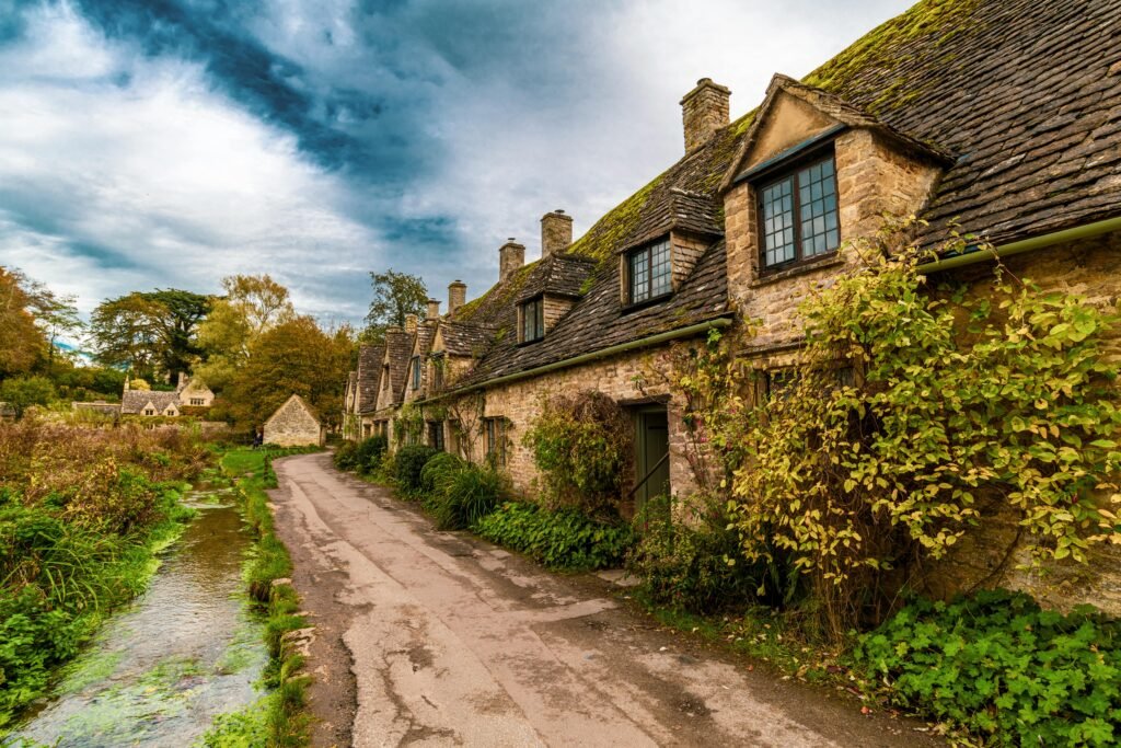 pexels-photo-8202753-8202753 Picturesque stone cottages along a scenic road in Bibury, England, UK.